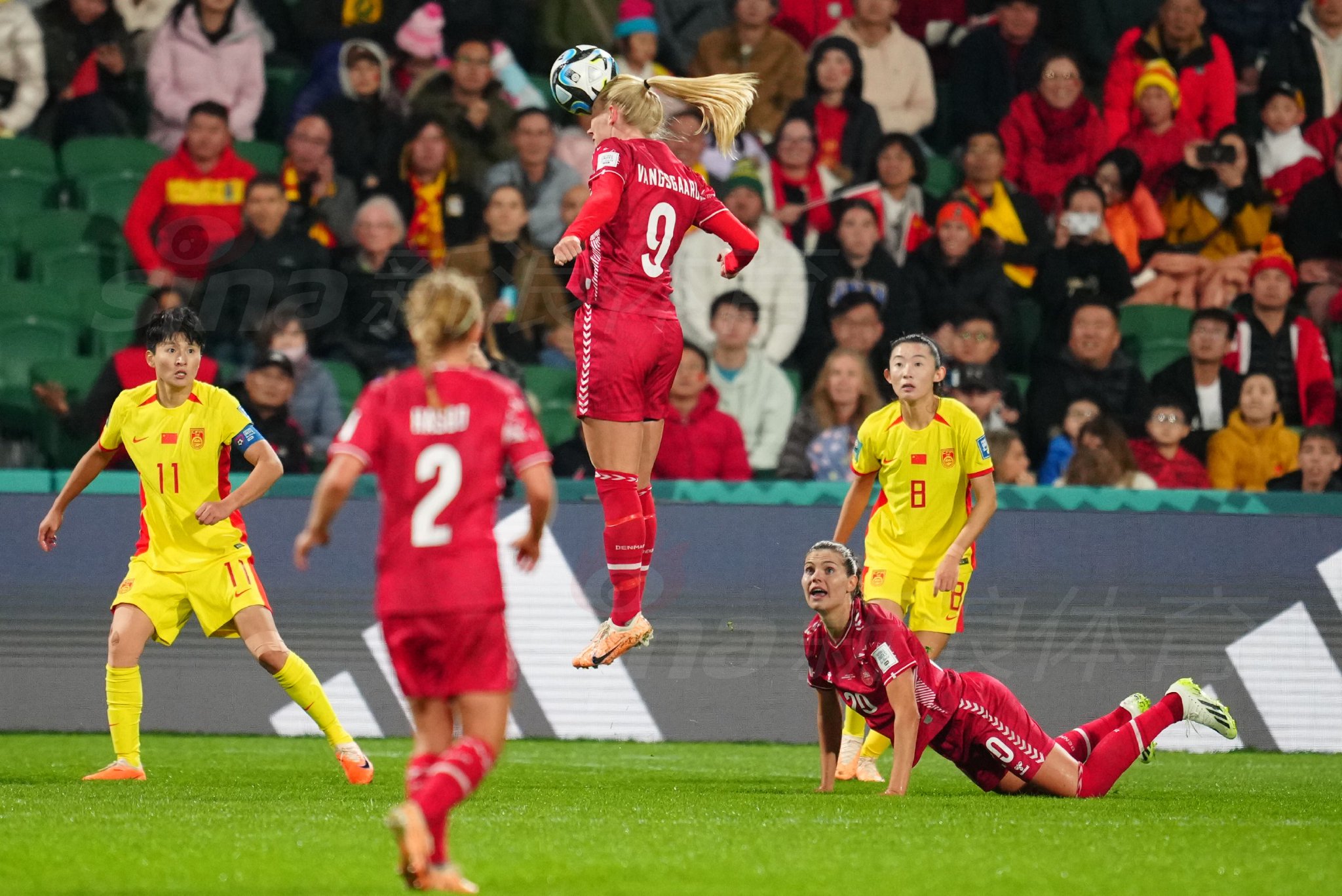 丹麦队前锋在禁区前沿起脚劲射，皮球如出膛炮弹般飞向球门，中国门将朱钰飞身侧扑，身体在空中完全舒展，奋力将球挡出底线。