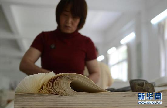  5月11日，安徽省泾县宣纸厂工人在进行检纸作业。新华社记者韩晓雨摄