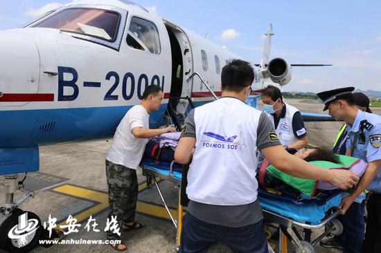 黄山边检民警帮助医护人员将沉重的担架抬上飞机