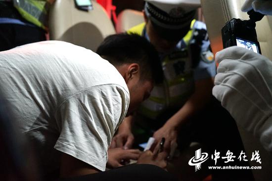 被查到饮酒驾驶的司机正在处罚单上签字