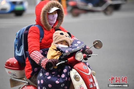资料图：12月2日，民众着厚重的冬装出行。 中新社记者 刘冉阳 摄