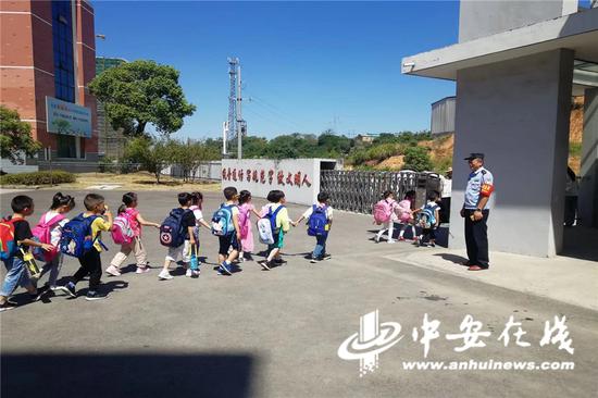 图为铜陵郊区派出所民警何晓安坚守“护学岗”,保障小学生们的安全。