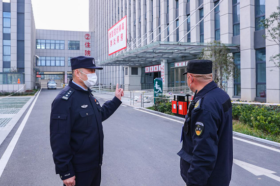 亳州市公安局治安支队四大队民警在新冠肺炎患者定点收容医院，为保安员讲解防护知识。