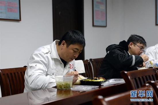 2月12日,陈晓亮(左)在蚌埠市紧急救援中心吃晚饭。新华社发(黄博涵 摄)