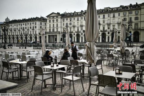 图为意大利都灵维托里奥广场露天咖啡馆。受新冠疫情影响，街上人迹寥寥。