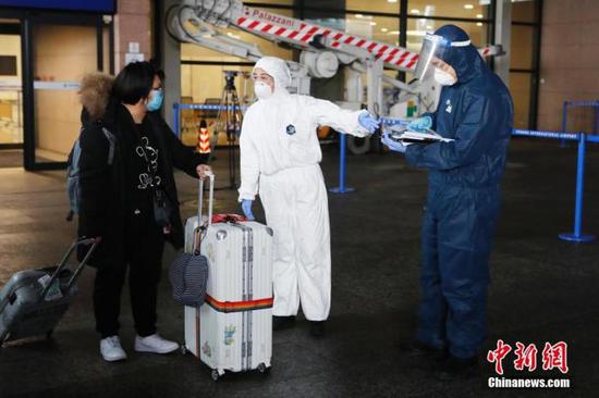 上海浦东机场工作人员指引一位入境旅客前往集中隔离观察点。中新社记者 殷立勤 摄