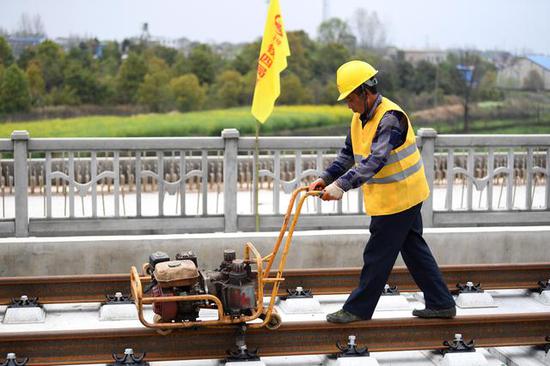 3月26日，中铁四局八分公司工人在进行铺轨作业。