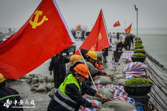 7月24日，暴雨如注，环湖北路巢湖大堤滨湖段，上海建工（安徽项目部） 组织60名抢险突击队对巢湖大堤进行加固