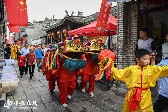 精彩的牛官堡武狮在古镇老街上展演