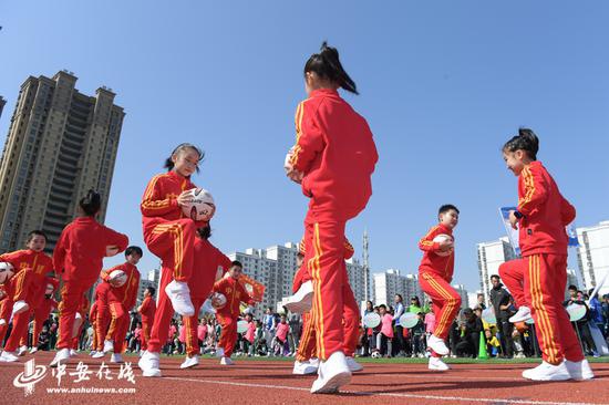 孩子们在开幕式上进行足球游戏表演