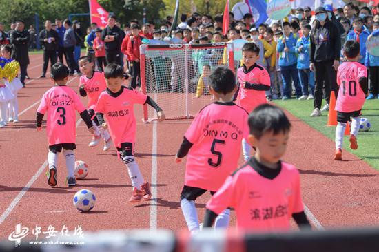 孩子们在开幕式上进行足球游戏表演