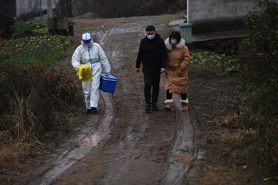 褚诗波和镇村干部一起，踏着泥泞的村道去村民家做核酸检测。 吴芳摄