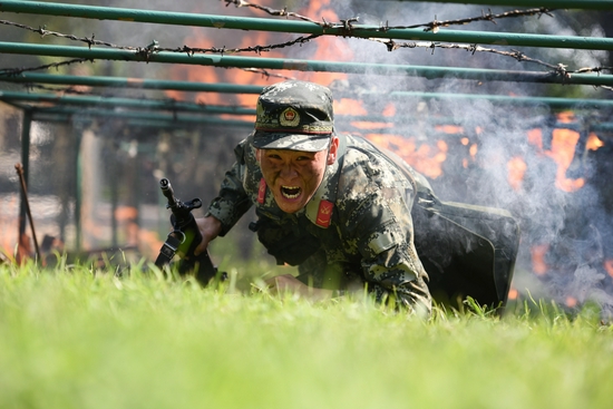 　　武警合肥支队执勤六中队官兵在烈日下进行快速通过低桩网火障。