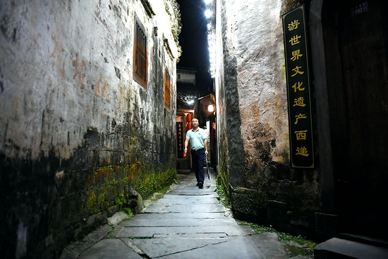 　7月29日深夜，卢磊在西递村的街巷里打更。