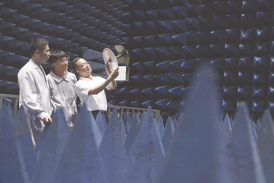 吴剑旗院士（右一）在中国电科38所微波暗室指导科研人员进行装备测试工作。