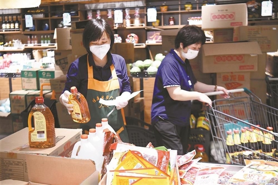 7月4日，泗县佳美超市的工作人员根据线上订单分拣商品，保障居民生活物资供应。黄博涵 摄