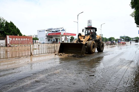 6月21日，在黄山市歙县县城，工作人员在清理淤泥。新华社记者黄博涵 摄