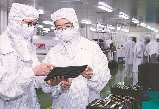 吴剑旗院士（右）在中国电科38所微波中心和科研人员商酌先进封装技术。
