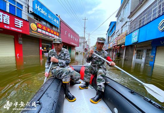 父子俩在被洪水淹没的老街乘坐皮划艇巡查