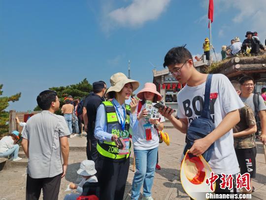  黄山风景区志愿者在光明顶耐心给客人指路。　汪新平 摄