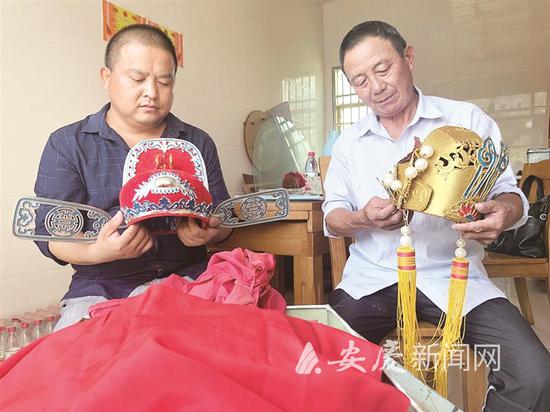 图为赵章存(左)正在整理戏曲服饰