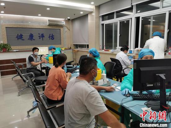 5月15日晚，在合肥市安徽国际旅行卫生保健中心新冠疫苗免费接种点，工作人员正在为市民接种疫苗。　储玮玮 摄