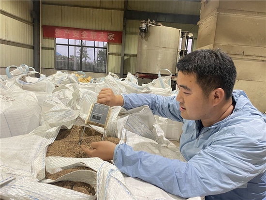 7月7日，安徽省滁州市天长市种粮大户平东林在秸秆炭化厂房用水分测定仪检测秸秆炭粉水分指标。新华社发（朱礼明 摄）