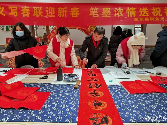2024年2月2日，在安徽省合肥市肥东县众兴乡先锋农场，文艺志愿者为当地农户写春联送祝福。