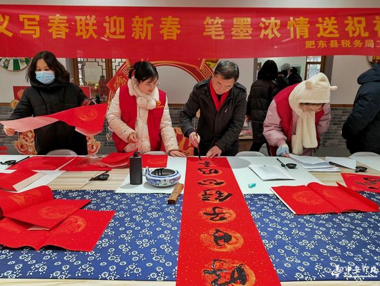 2024年2月2日,在安徽省合肥市肥东县众兴乡先锋农场,文艺志愿者为当地农户写春联送祝福。