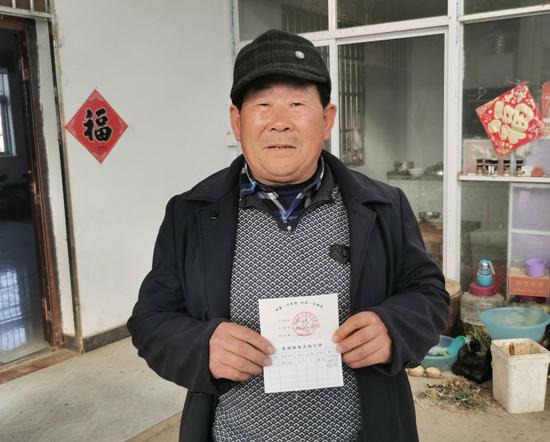 小岗村村民殷广为向记者展示“美德银行”善行美德积分“存折”。 新华社记者姜刚 摄