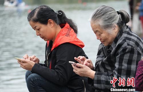 图为中国中老年女性使用智能手机上网。（资料图） 刘占昆 摄