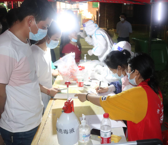 青年志愿者协助核酸检测点的医护人员进行采样信息录入
