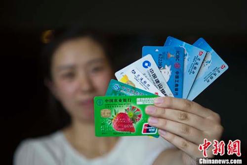 资料图:民众展示银行卡。 中新社记者 张云 摄