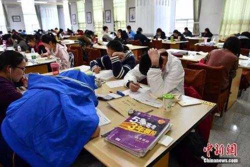 资料图:昆明中小学生在图书馆自习室内写作业。