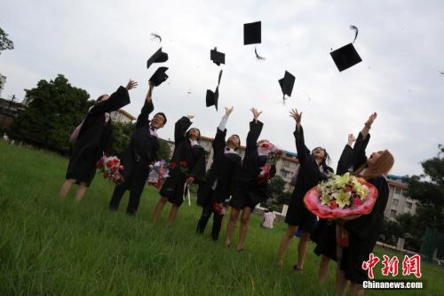 图为留学生抛帽子庆祝毕业。中新社发 赵琳露 摄