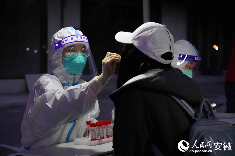 安徽省合肥市琥珀街道北苑村社区核酸检测点，采样人员正在进行核酸采样。人民网 陈若天摄