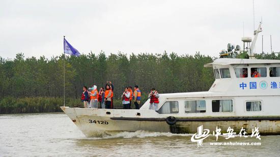  采访团记者与巡护队员一起在江面上乘船巡逻