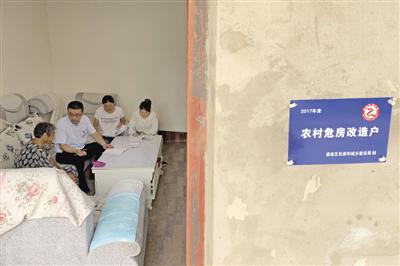 和同事在危房改造的村民家中回访