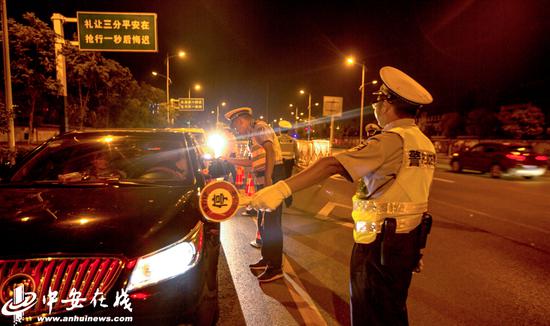 庐江县公安局的交通民警正在城区黄山南路查处在地图中查看酒驾，确保节日期间道路交通安全