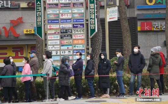 资料图：3月1日，在首尔钟路区一家超市外，民众排起长队等待购买口罩。中新社记者 曾鼐 摄