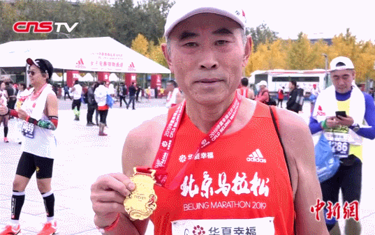  刘玉琪展示他的完赛奖牌。