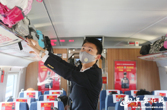 2月20日,约1000名阜阳及周边地区务工人员乘g9413次返程专列前往义乌。列车乘务员在整理行李架,为旅客提供舒适整洁的乘车环境。 梁浩然 摄