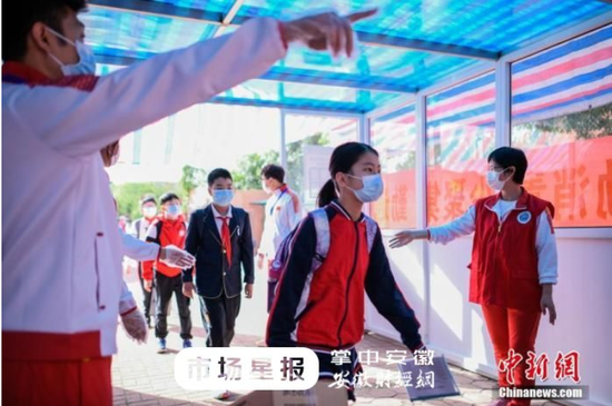 资料图：小学生通过体温检测通道进入校园。中新社记者 佟郁 摄