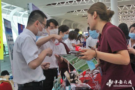 “航空集市”活动现场，各家航司工作人员向旅客介绍航空旅游优惠产品及抢购方式。