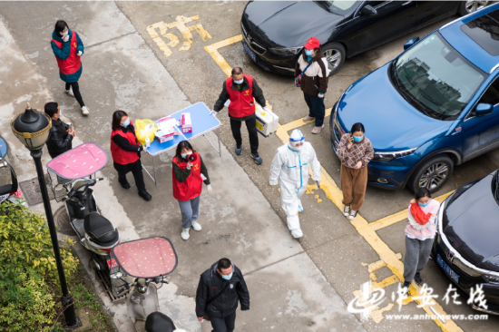 芜湖市繁昌区峨山镇金峨社区，医务人员和志愿者在荷塘小区里进行流动核酸采样
