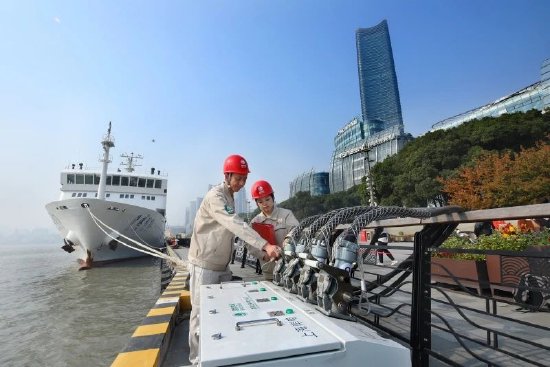 国网上海市区供电公司员工在上海港国际客运中心检查调试船舶岸电系统