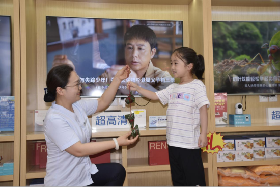 (营业厅的工作人员带着小朋友一起包粽子)