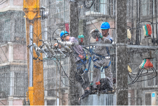 8月11日，国网铜陵供电公司员工在暴雨中进行抢修作业。（郜小兵 摄）