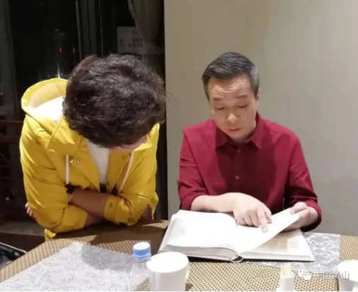 总导演颜芳（左）和康震教授（右）在查阅《黄山志》