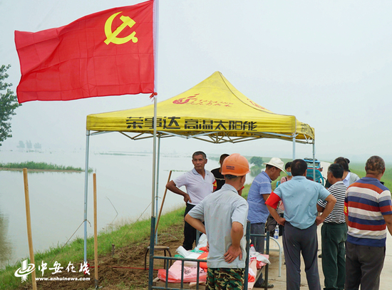 7月21日，五河县朱顶镇珩庄党员干部在淮河大堤巡堤。